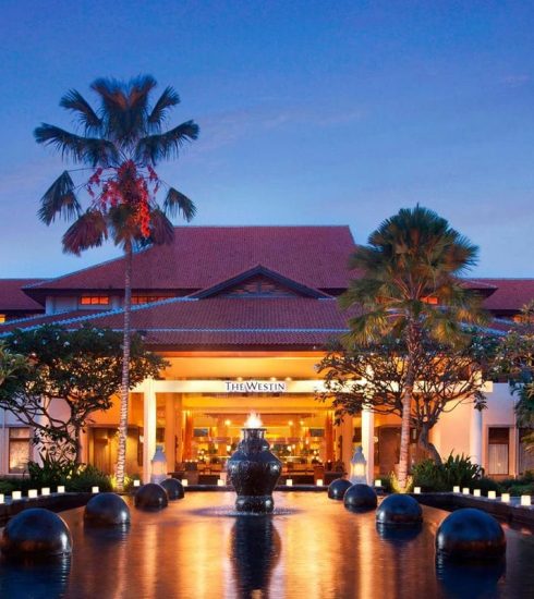 A resort in bali at night with a water feature.